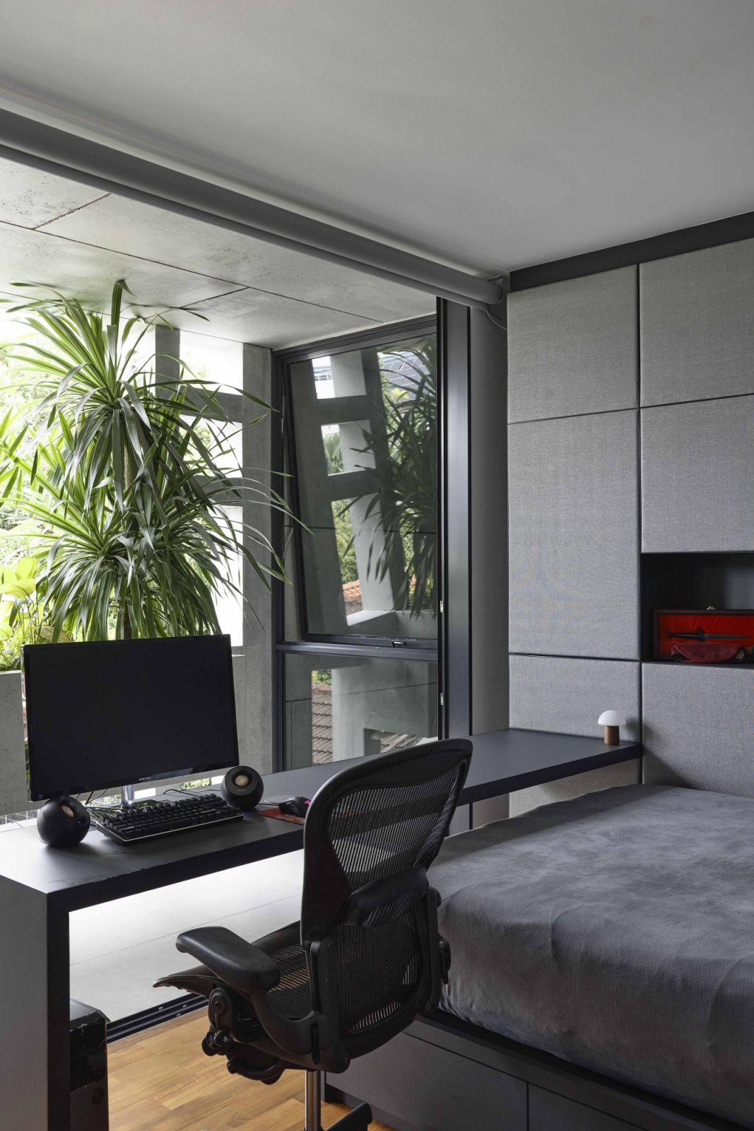 This bedroom with a study enjoys a lush view of the balcony