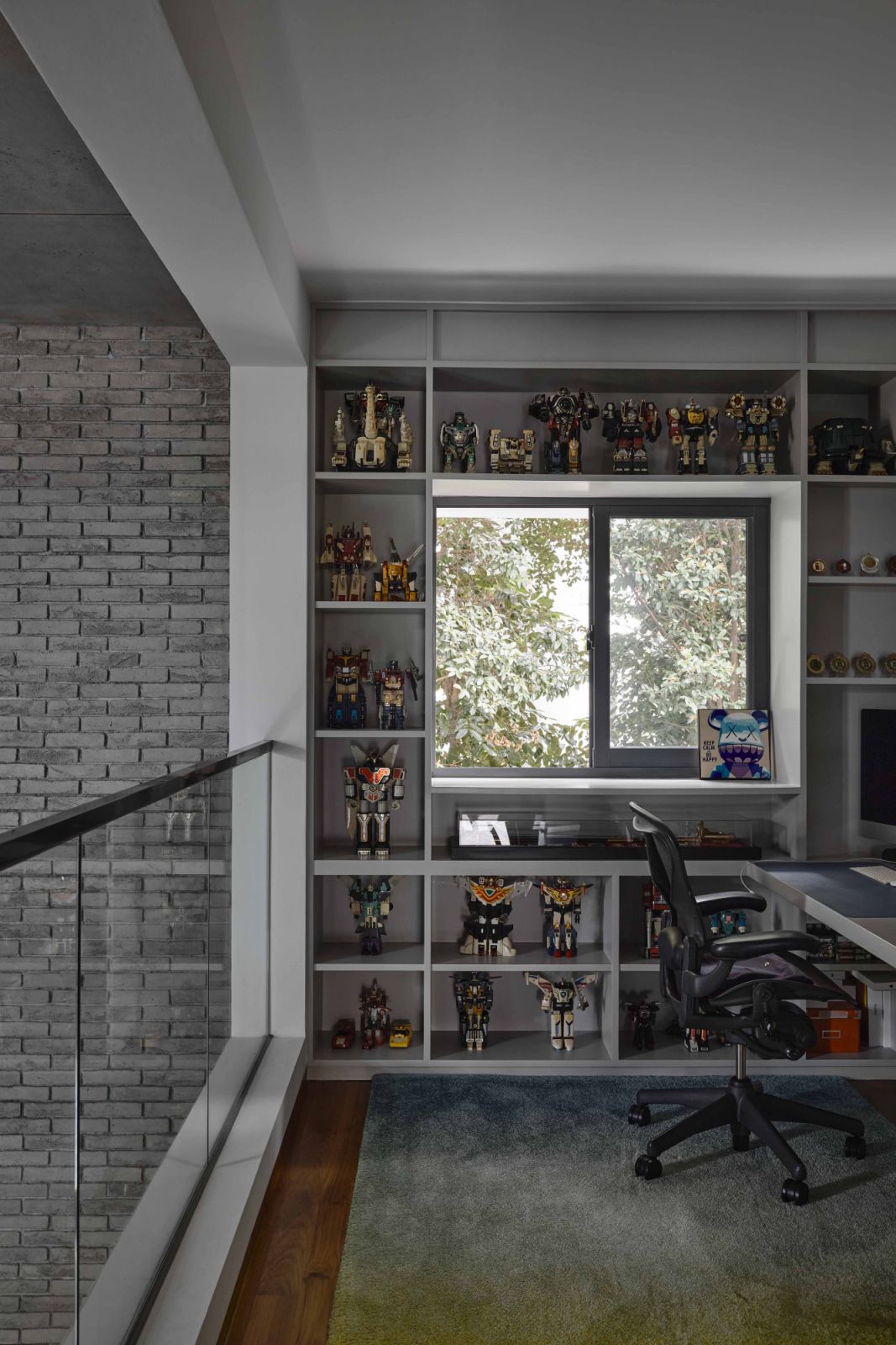 Display shelves frame a picture window, turning the homeowner’s figurine collection into an interior feature
