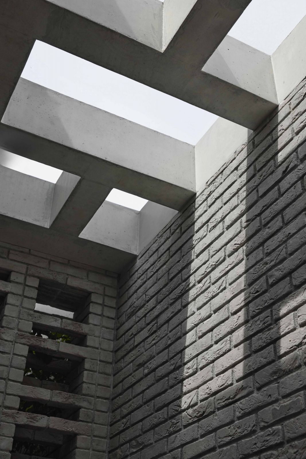 The concrete structure of the skylight transforms it into a patterned screen