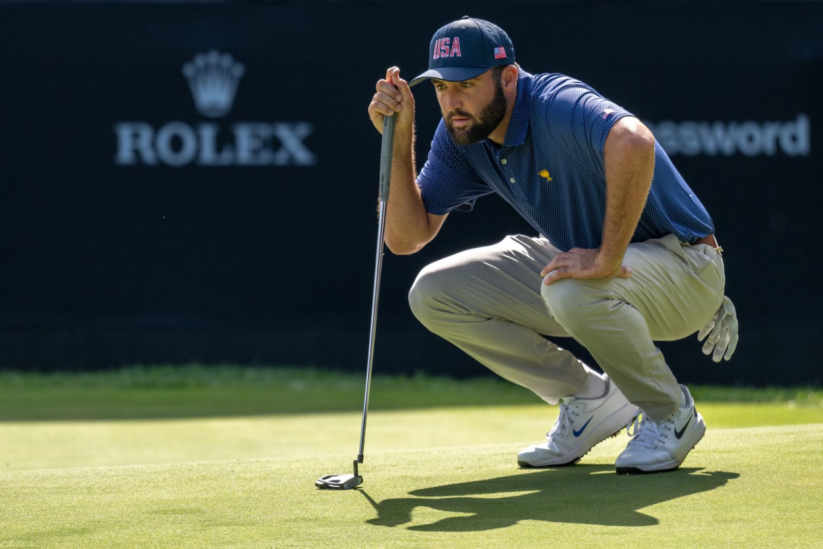 Scottie Scheffler of the United States Team lines up a putt on the fourteenth green during the Saturday four-balls