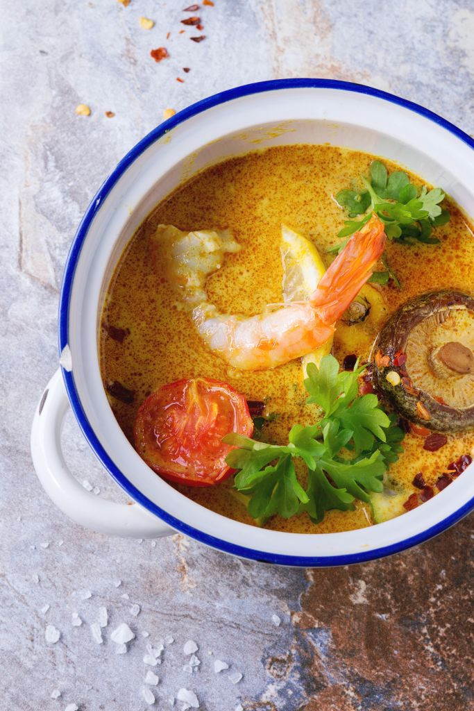 White Ceramic pan with Spicy Thai soup Tom Yam with Coconut milk, Chili pepper and Shrimp over gray stone background. Top view. (Photo by: Natasha Breen/REDA/Universal Images Group via Getty Images)
