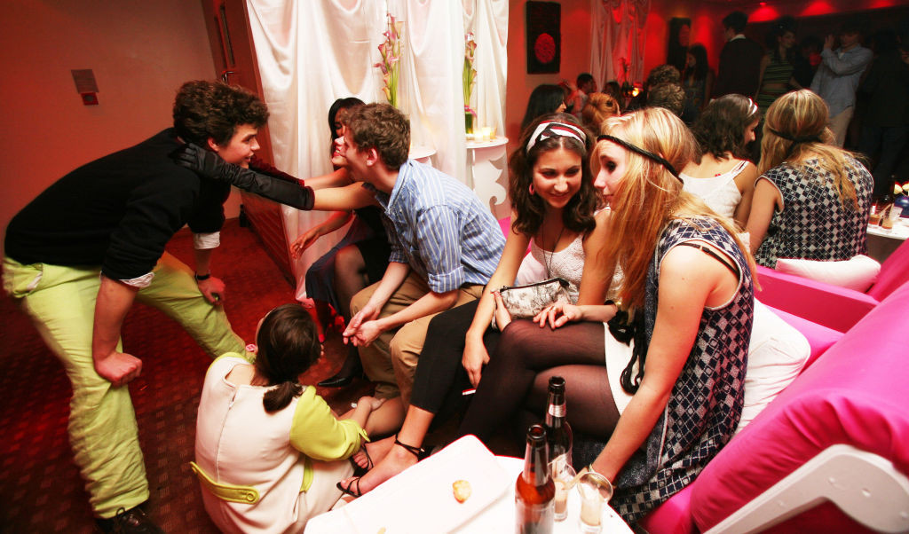 Group of young adults, talking and drinking, female in long velvet black gloves leaning on male with pastel green trousers, 18th Birthday Party, Nobu Metropolitan Hotel, 2006. (Photo by Eleanor Lindsay-Finn/PYMCA/Avalon/Getty Images)