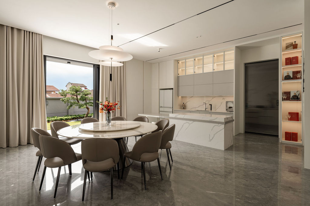 The open-concept dining and kitchen area showcasing the stone flooring and marble coordination, with natural light guiding movement between zones as intended in the design.