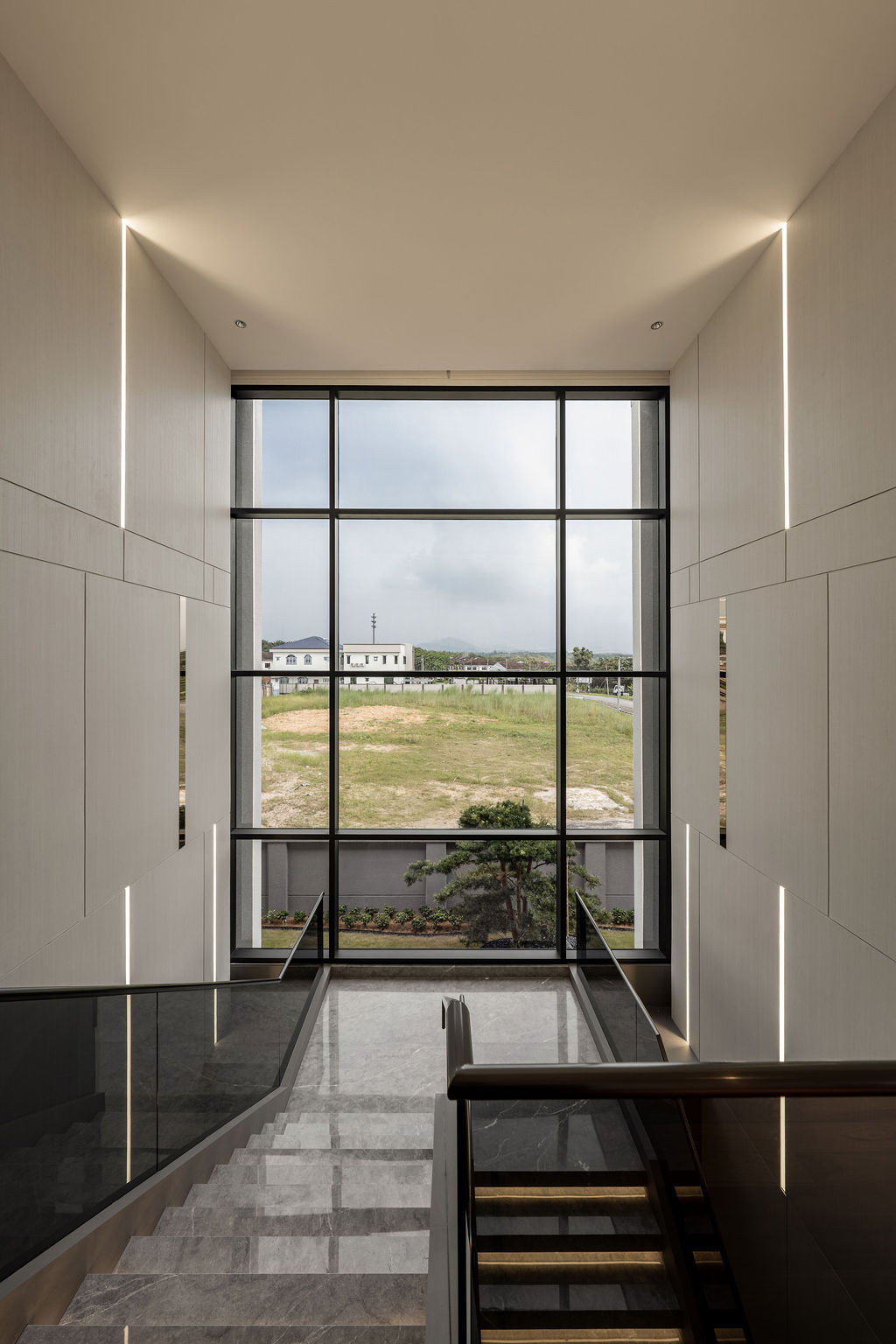 Upper level view showing the villa’s integration into the Bidor neighbourhood, with natural light filtering through the precise material transitions that required extensive contractor coordination