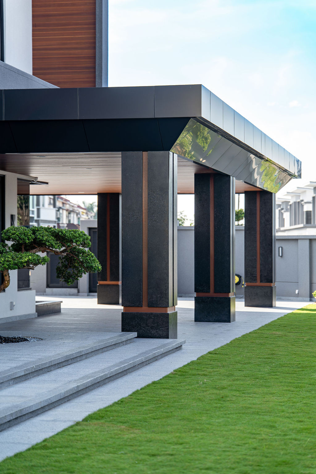 The covered entrance portico demonstrates the careful attention to material pairing and the weather-resistant finishes chosen for Malaysia’s climate.