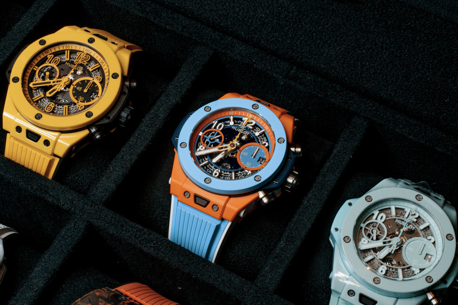 Hublot Big Bang Unico Summer 2025 (centre) with orange ceramic case and sky blue bezel, flanked by its equally vibrant predecessors