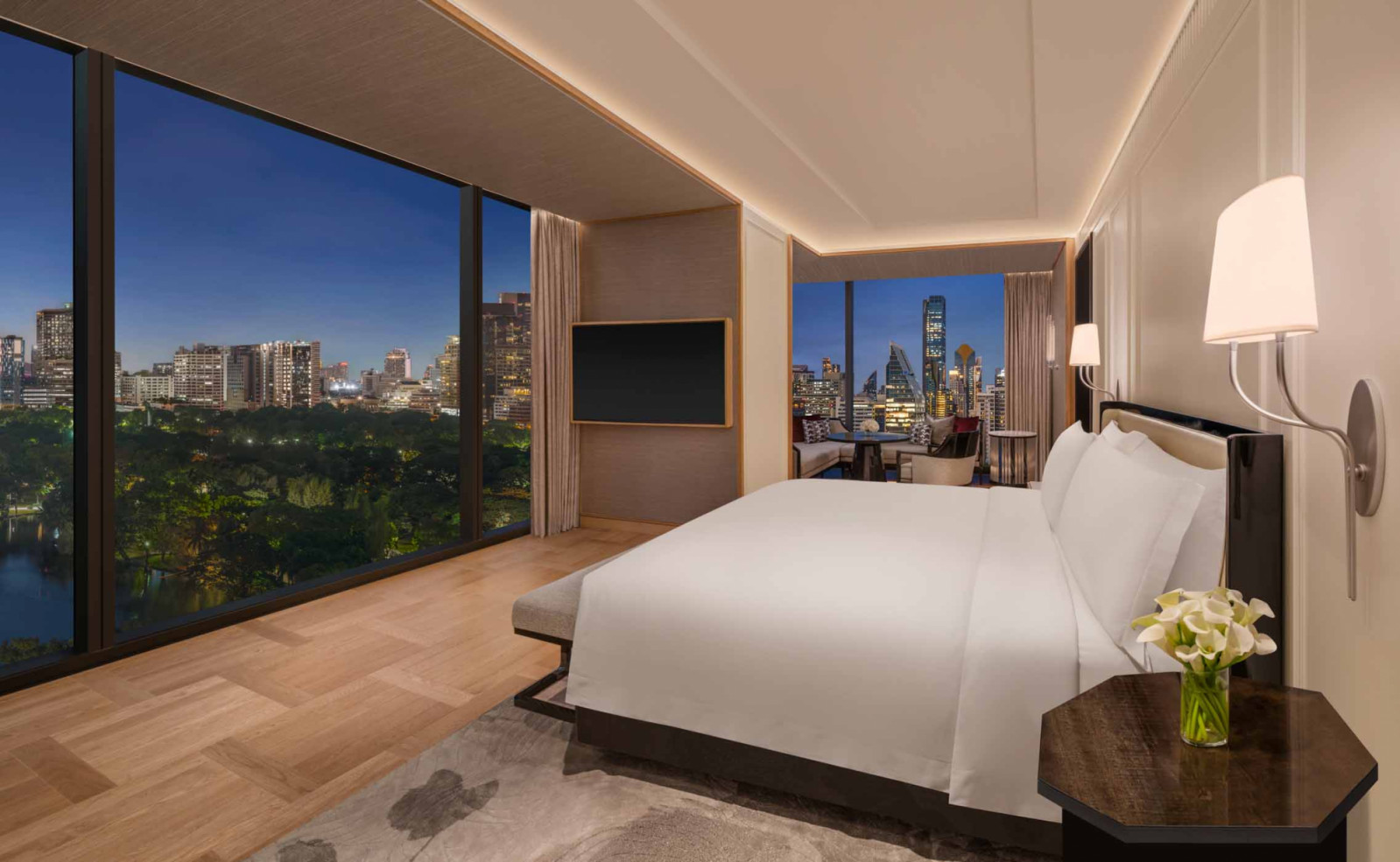 The Marigold Suite at The Ritz-Carlton, Bangkok offers sweeping twilight views of Lumpini Park from a private balcony