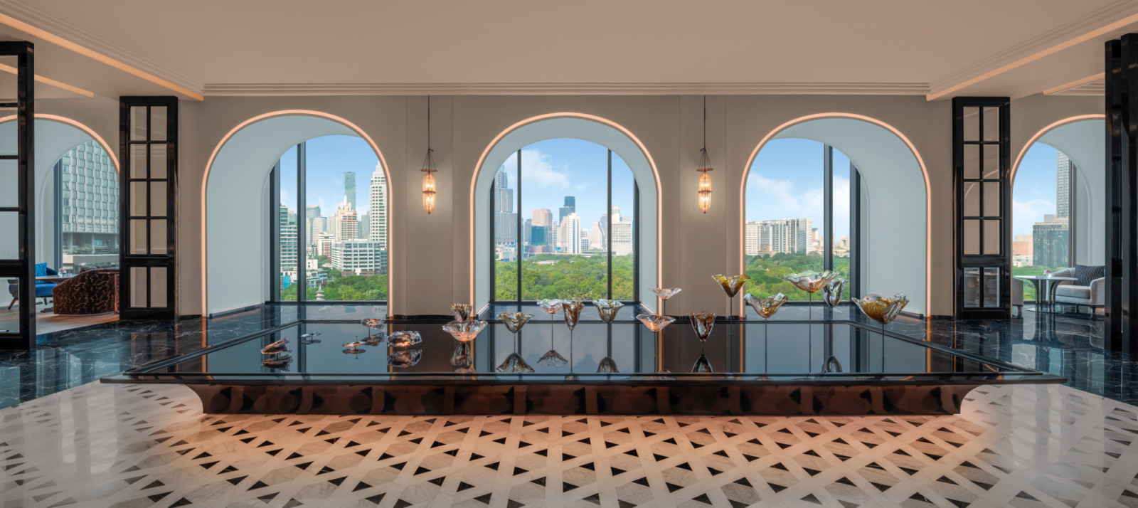 A dramatic reveal as guests exit the lift on the ninth floor where arched openings, a “lily” pond, and sculptural glasswork set the spatial tone