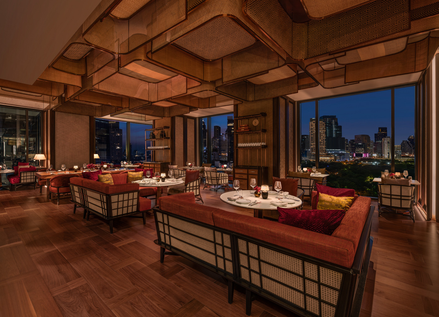 Lily’s at The Ritz-Carlton, Bangkok glows with warm timber tones, wood-and-rattan textures, and skyline views
