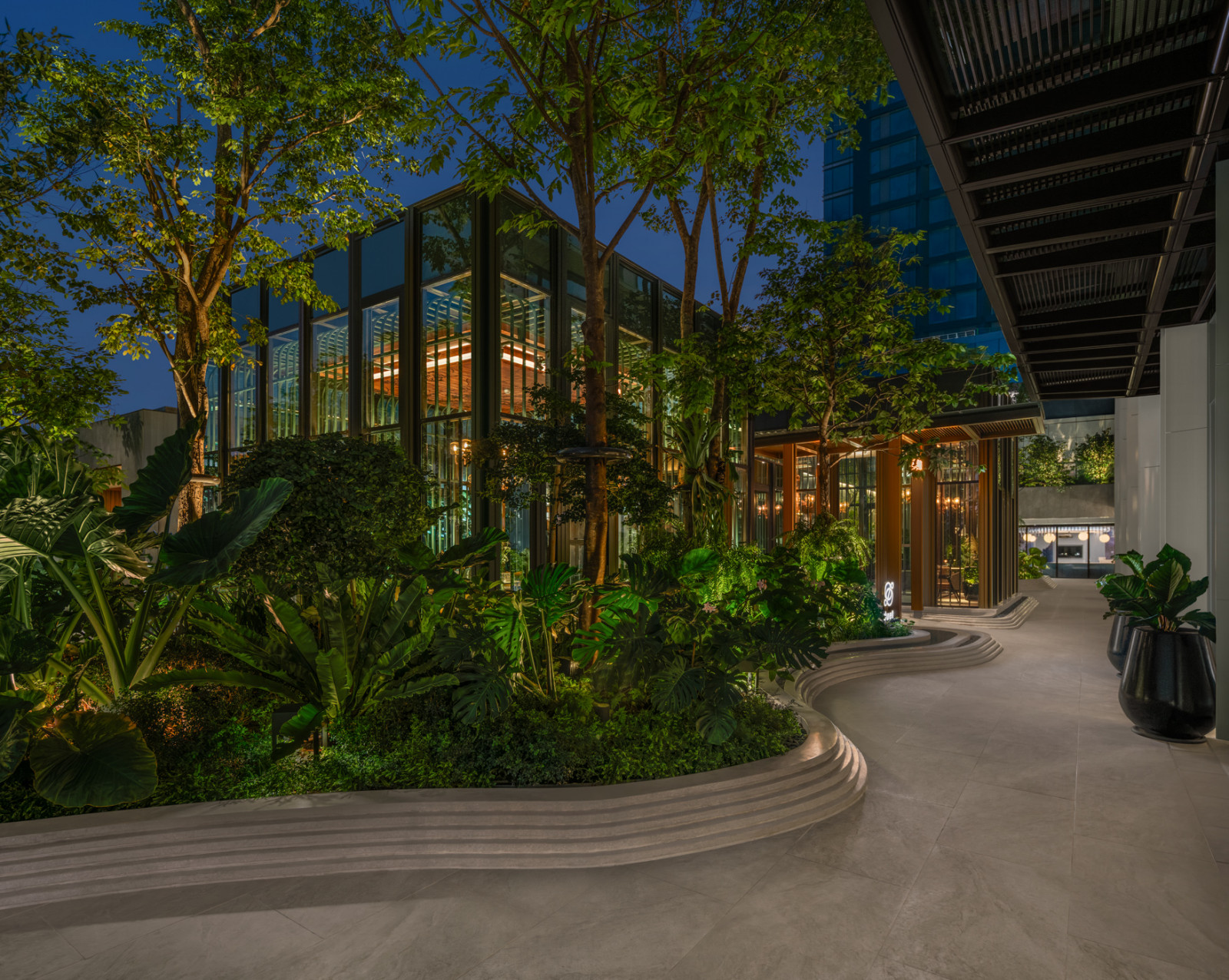 Twilight exterior of Duet by David Toutain at The Ritz-Carlton, Bangkok framed by greenery