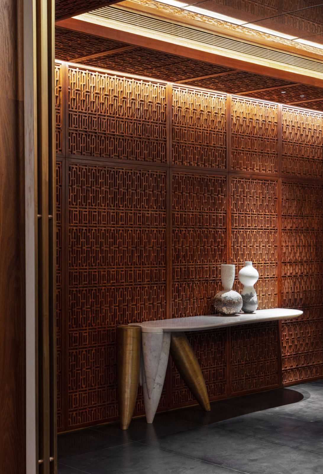 The Kashmiri pinjirakari latticework dominates an entire wall of the basement, demonstrating the intricate wooden screening technique that filters daylight
