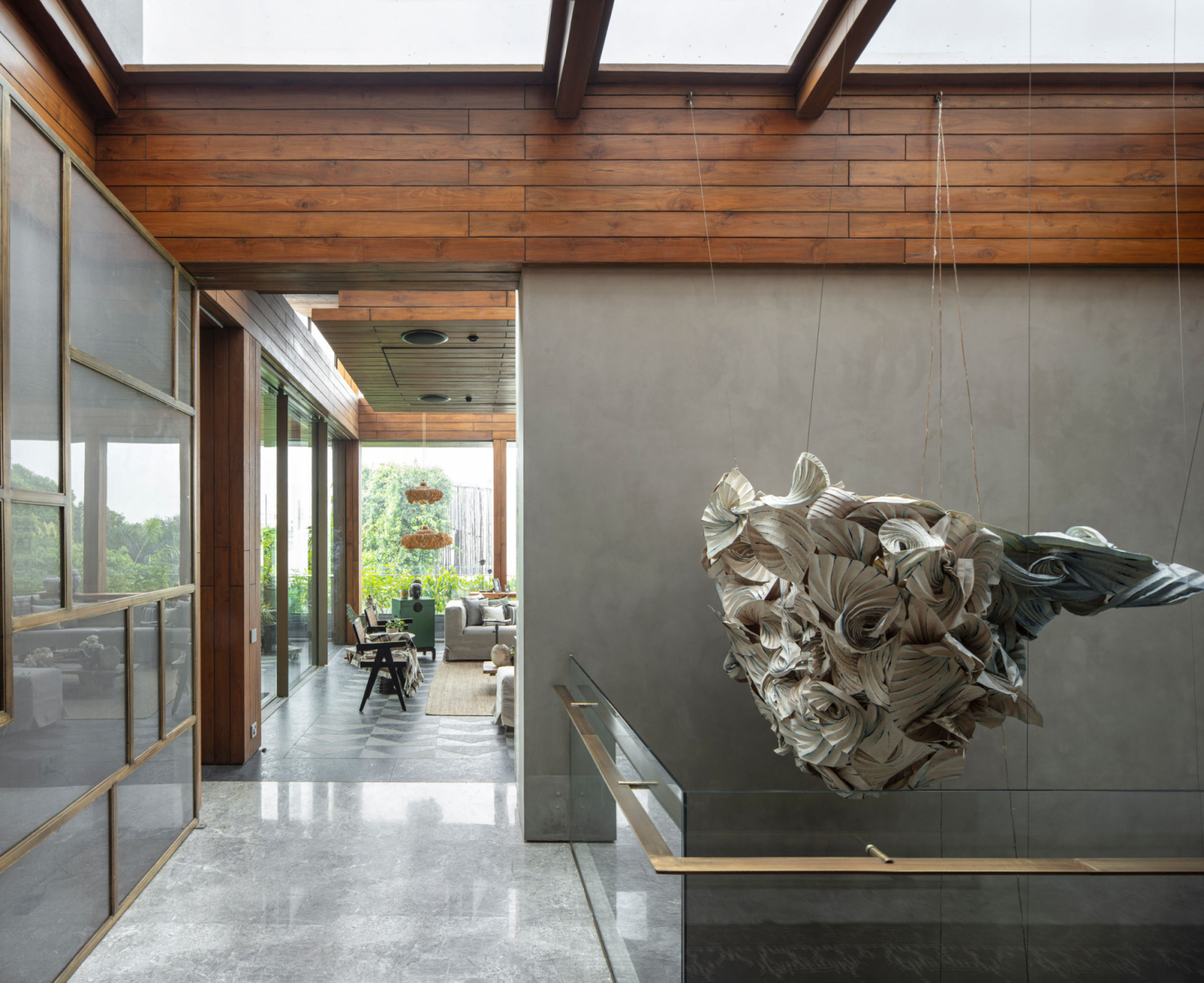 The central atrium showcases Ankon Mitra's paper installation suspended above the staircase, where Sanjhi craft elements create shifting light patterns