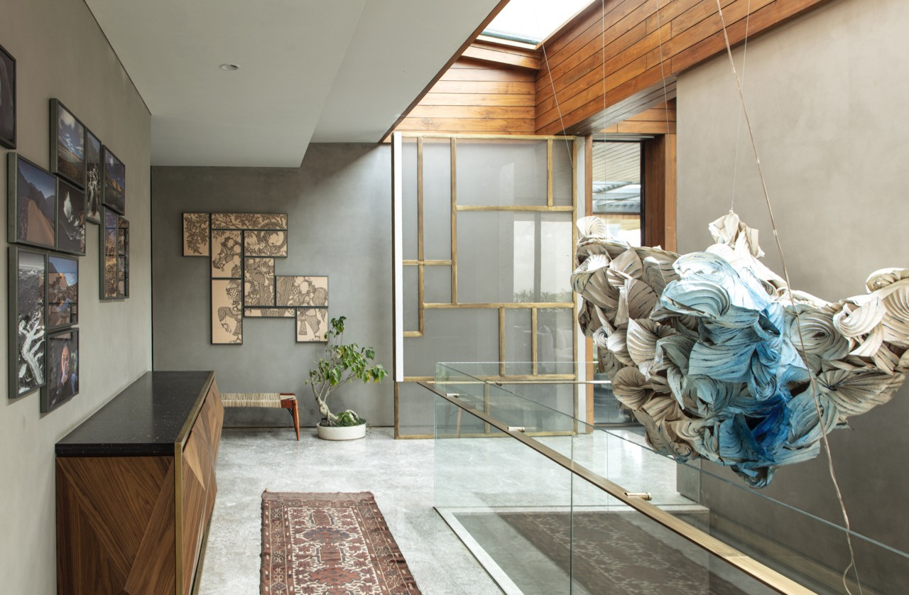 The central staircase showcases Ankon Mitra's suspended origami installation in the atrium, where Sanjhi craft elements create shifting light patterns throughout the day