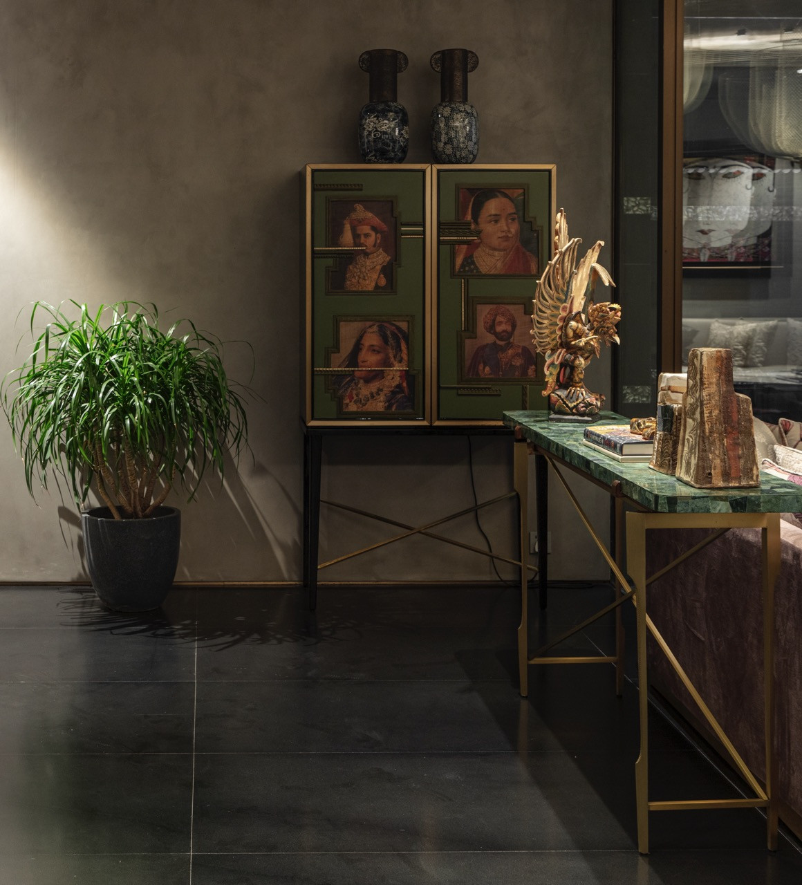 A console area displays the careful curation of traditional portraits alongside contemporary furnishings, showing how each space contributes to the home’s distinct identity