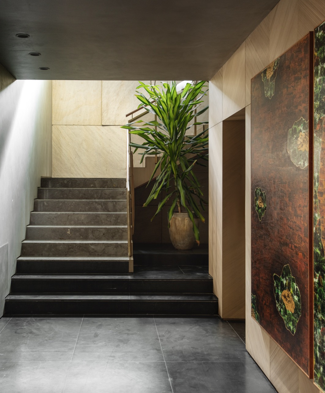 The staircase leading from the basement to the upper levels demonstrates material transitions between different zones of the house