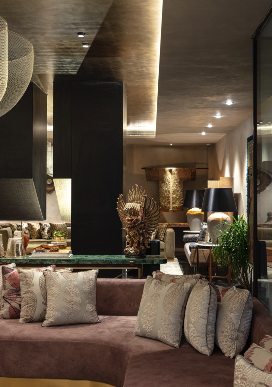 The basement entertaining area features large mesh pendant lights and sectional seating that proves subterranean formal spaces can function effectively