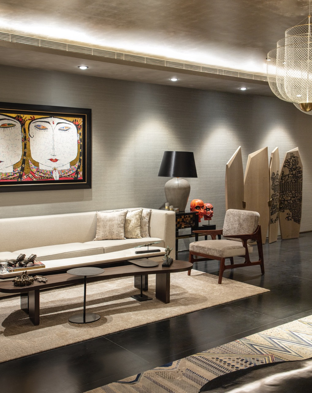 The basement living area features custom furniture by Furgonomics alongside vibrant artwork that stands out against the neutral foundation palette
