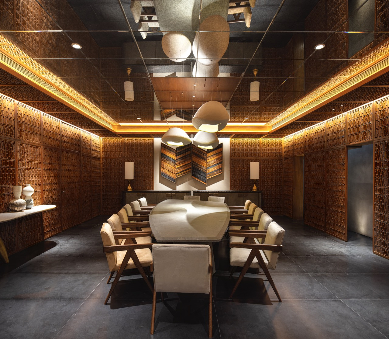 The main basement dining room showcases the full impact of Kashmiri pinjirakari latticework covering the entire walls, and Ankon Mitra’s origami installation hangs above the marble dining table