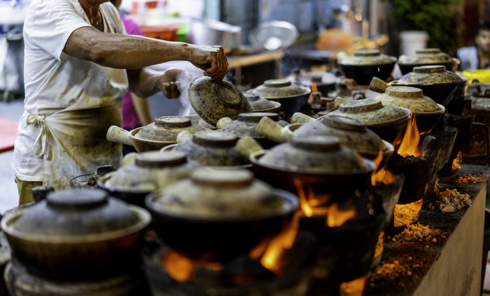 Malaysia Street Hawker cooking Clay pot Chicken Rice in night market at Kuala Lumpur.