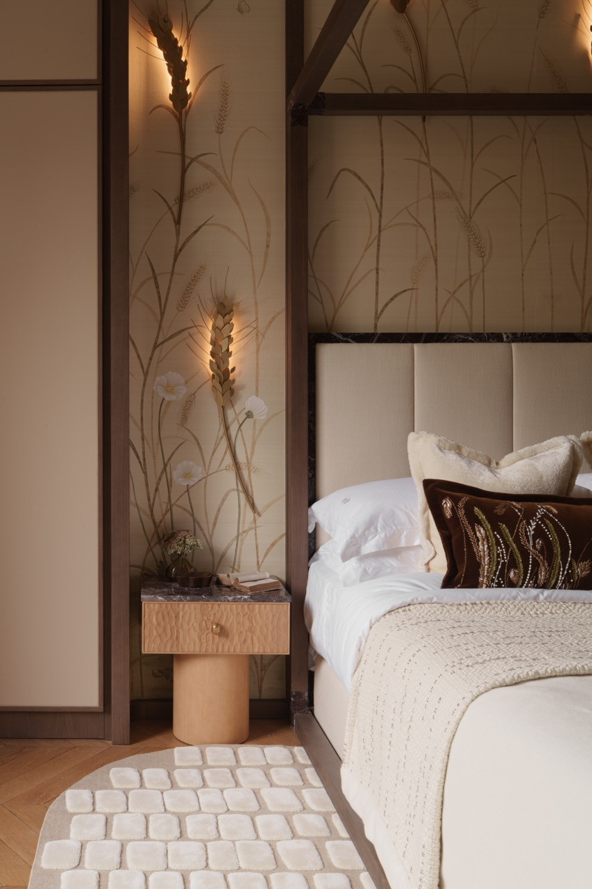 Hand-painted wheat field motifs transform into brass lighting fixtures in the main bedroom