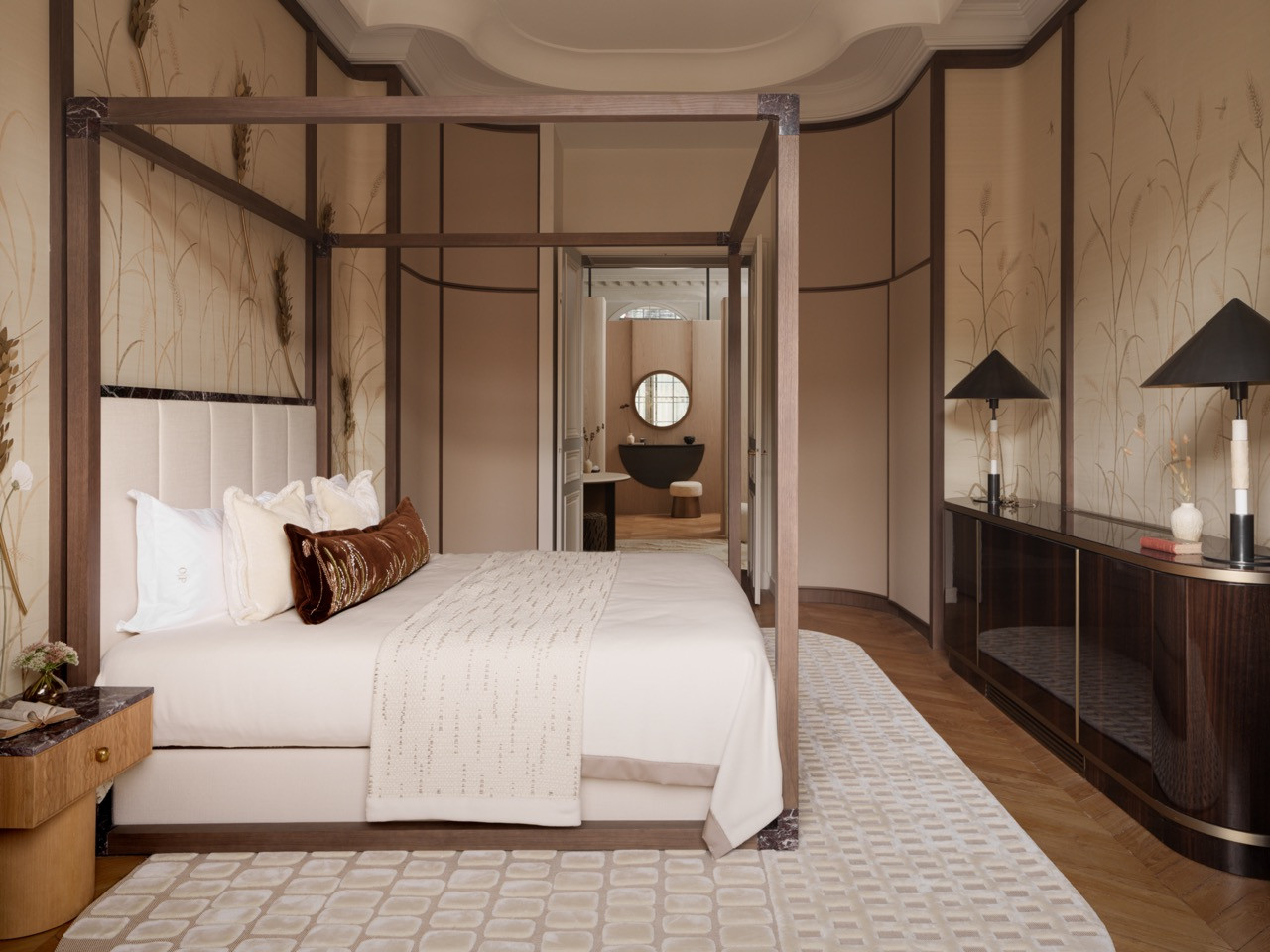 The main bedroom features hand-painted wheat field motifs that transform into brass lighting fixtures, with wallpaper creating what Ashby calls “a fully immersive experience."