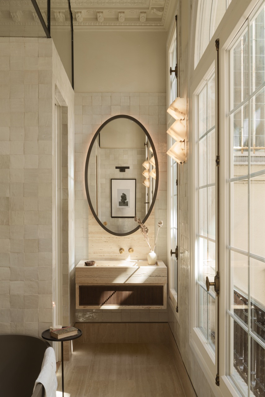 The main bathroom showcases three full-sized windows with a glass wall solution that preserves light flow