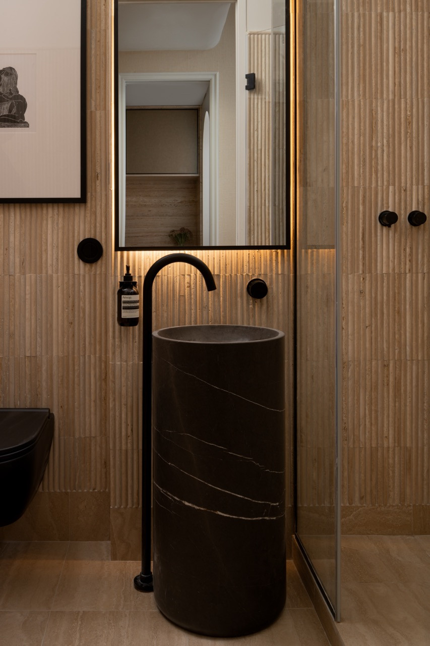 Fluted wood details and circular mirrors reflect Ashby's international design perspective, combining contemporary functionality with classical French architectural references