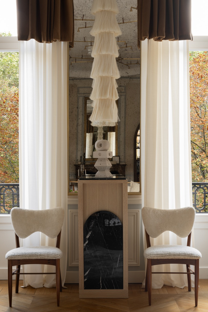 The living area features the inherited red marble fireplace and custom furnishings, with every room designed for circular movement, enhancing flow and connection