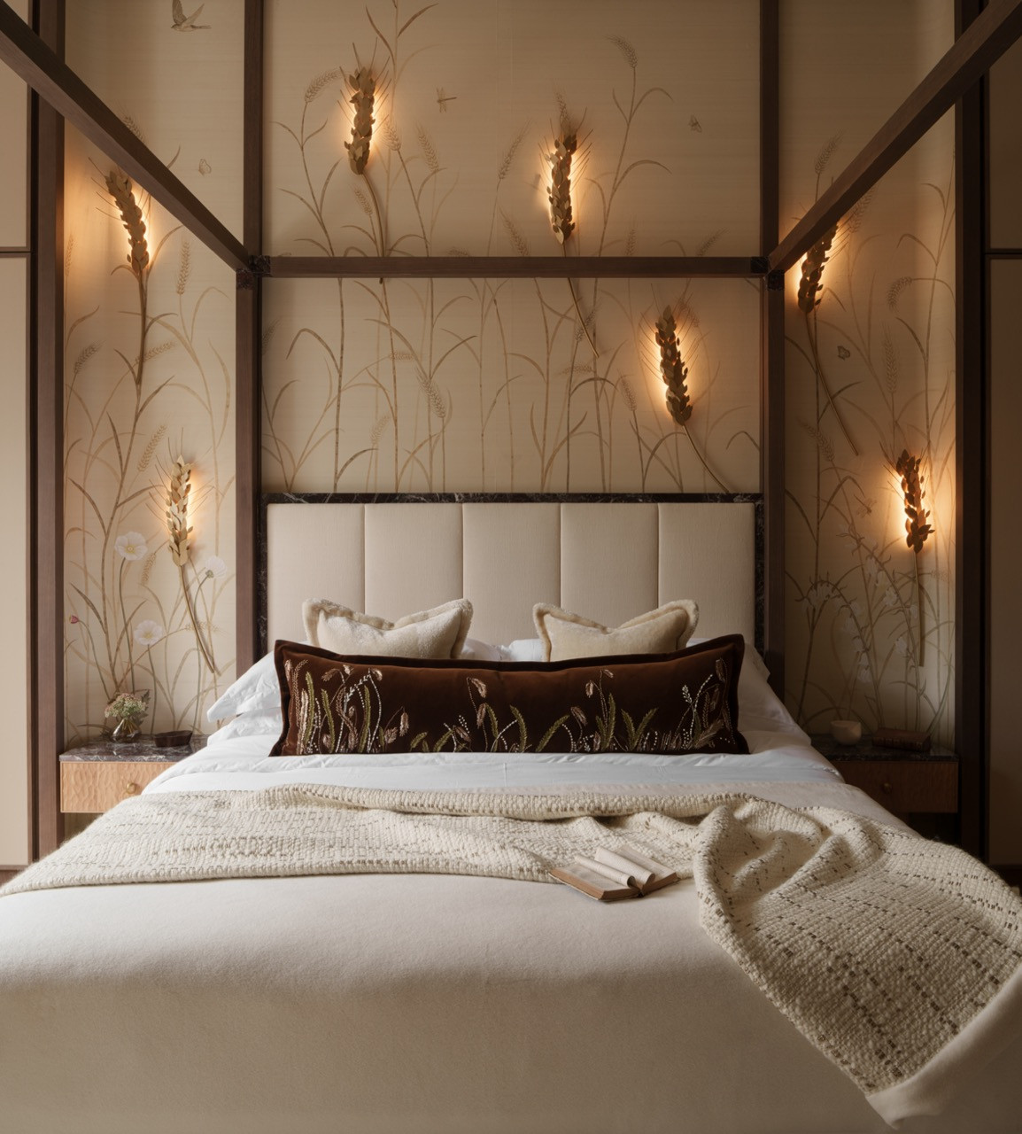 The main bedroom features the hand-painted wheat field panels and brass lighting fixtures, with the four-poster bed demonstrating the apartment's emphasis on display, not concealment