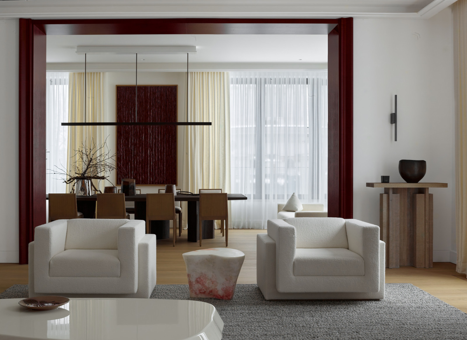 Berry-coloured accents, the client’s favoured red tones, punctuate the neutral backdrop