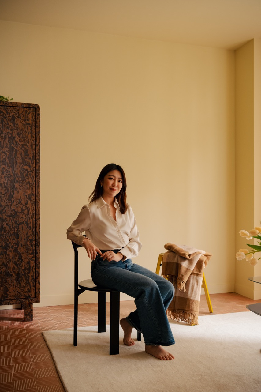 Gioh relaxes in her living space next to the California burl cabinet, which now houses her collection of “interesting plates and vases” gathered during travels.