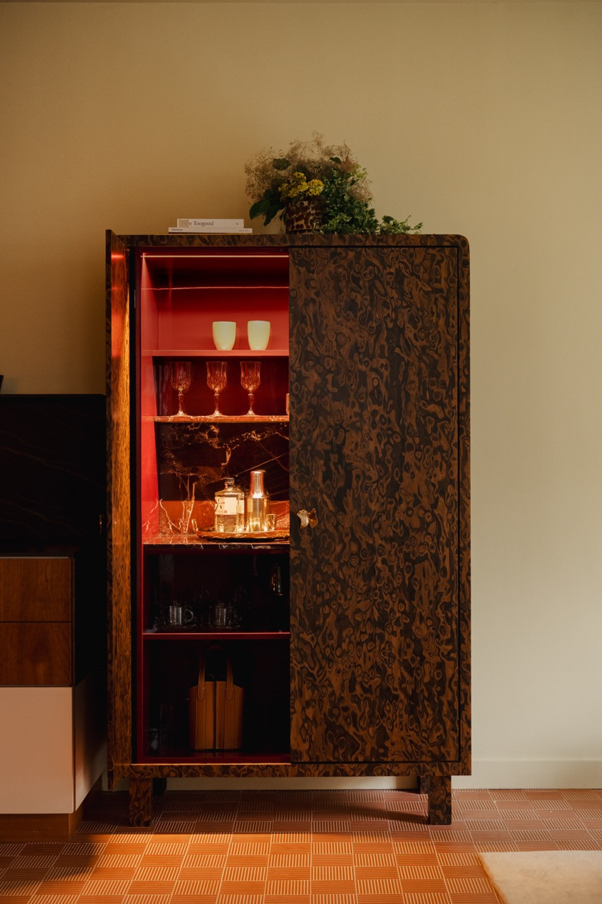 The cabinet opens to reveal its piano-gloss interior with red lighting, functioning as both a display and a bar, exactly as Gioh envisioned for entertaining and showcasing her collected pieces