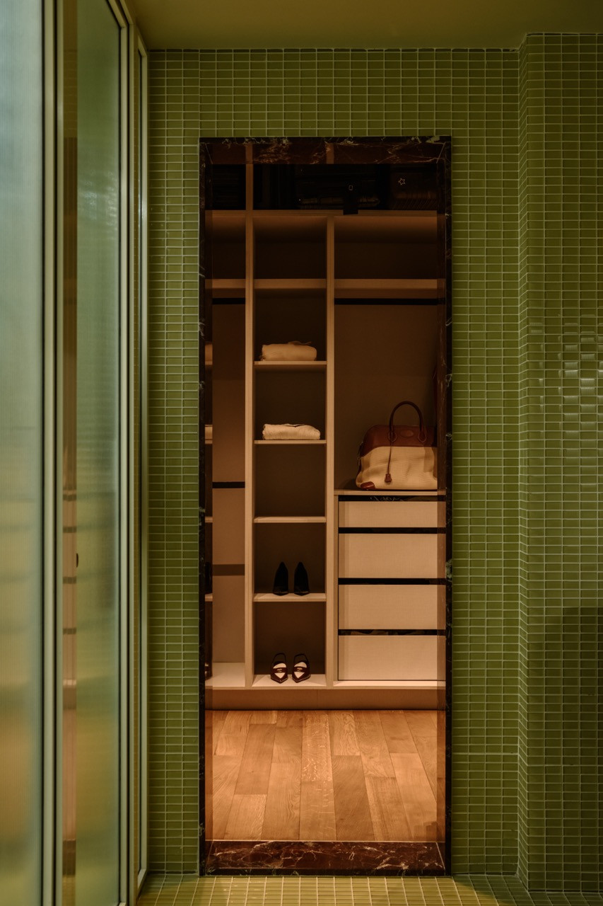 Looking into the wardrobe through the marble-framed doorway, where organised storage maximises the compact flat’s functionality—one of Gioh’s key priorities for efficient space usage