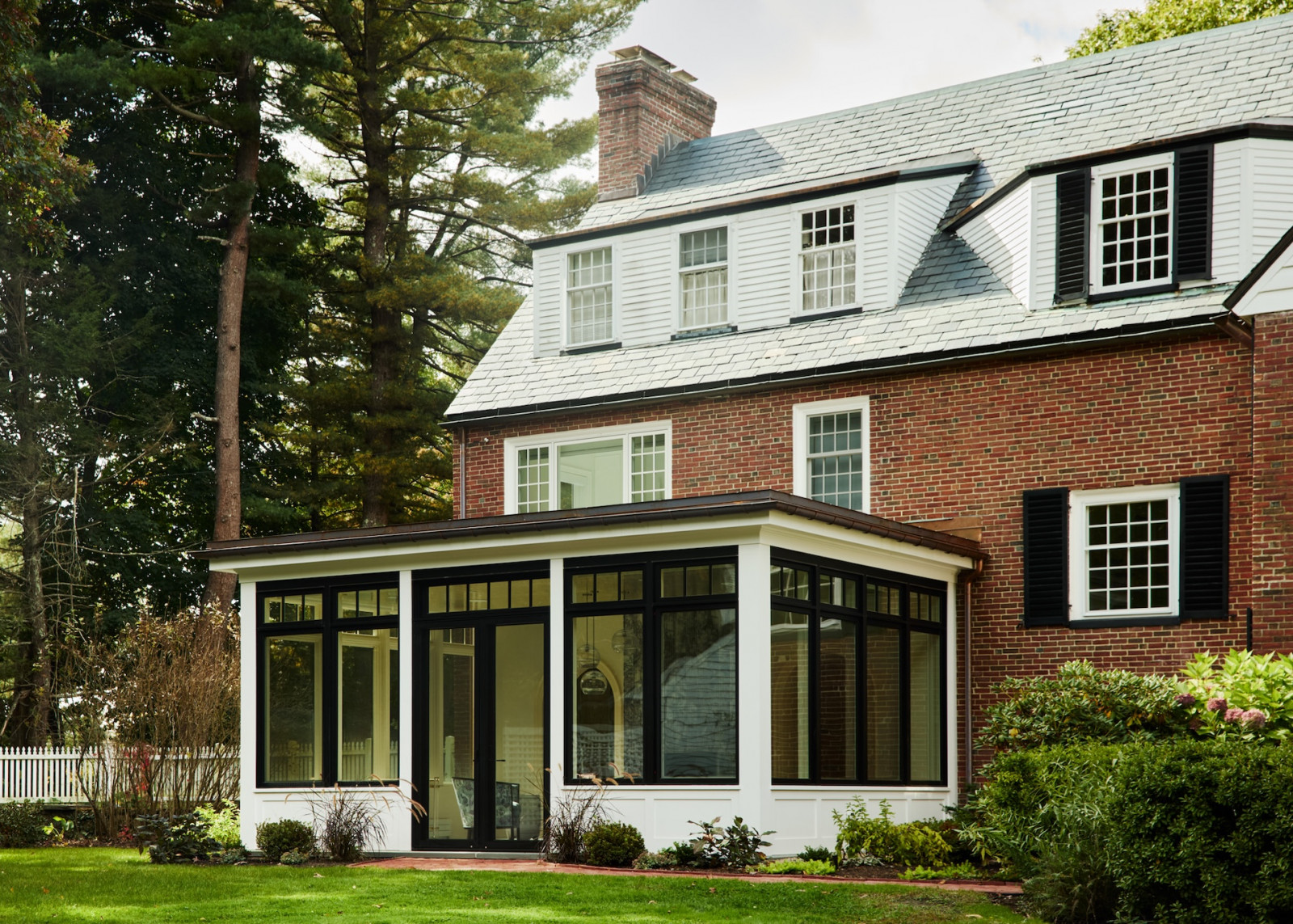 The exterior of a maximalist 1920s Georgian home in Boston that blends Mexican and Indian influences, designed by Vani Sayeed Studio