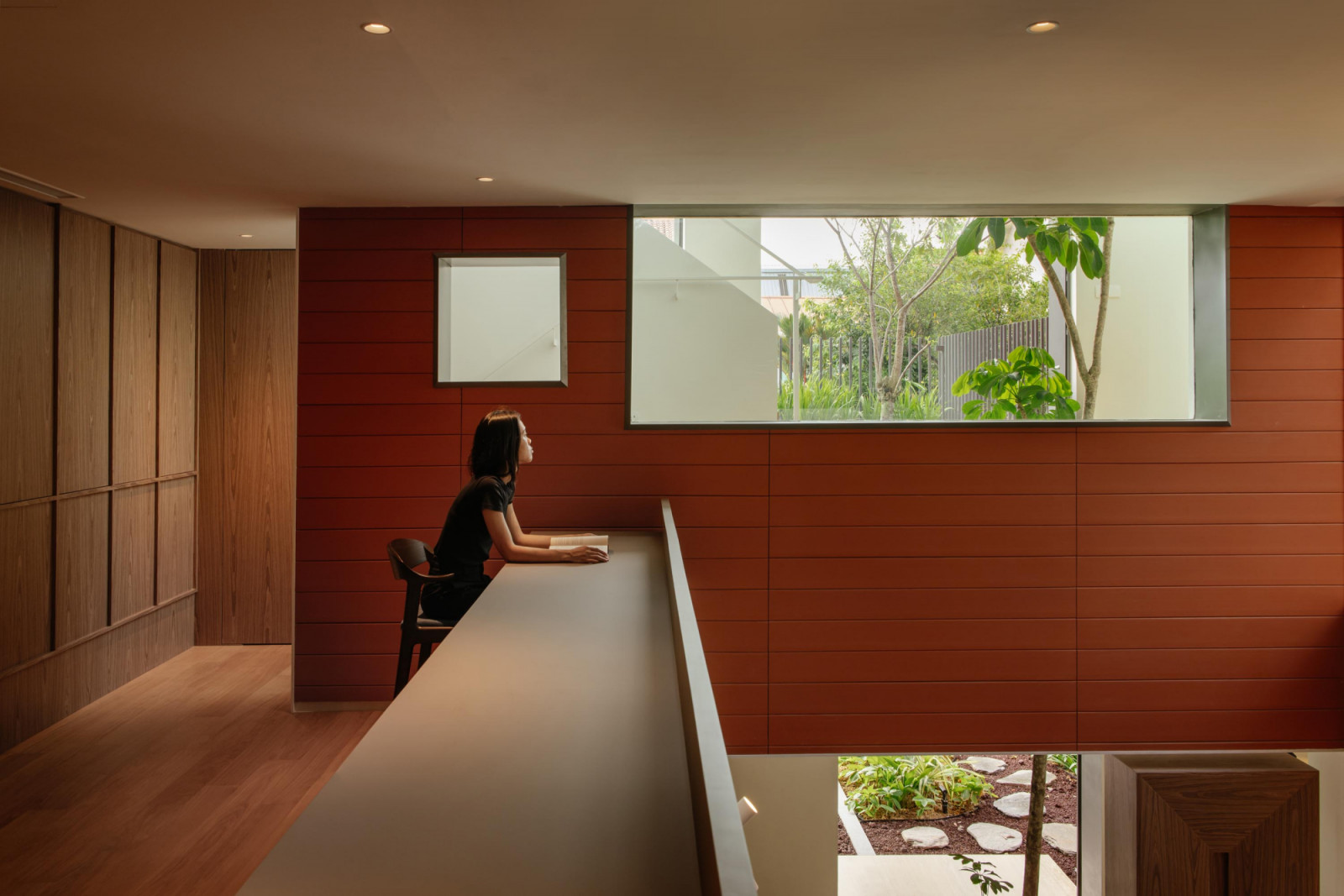 This mezzanine corridor was transformed into a study nook with views of the living area and the greenery beyond;