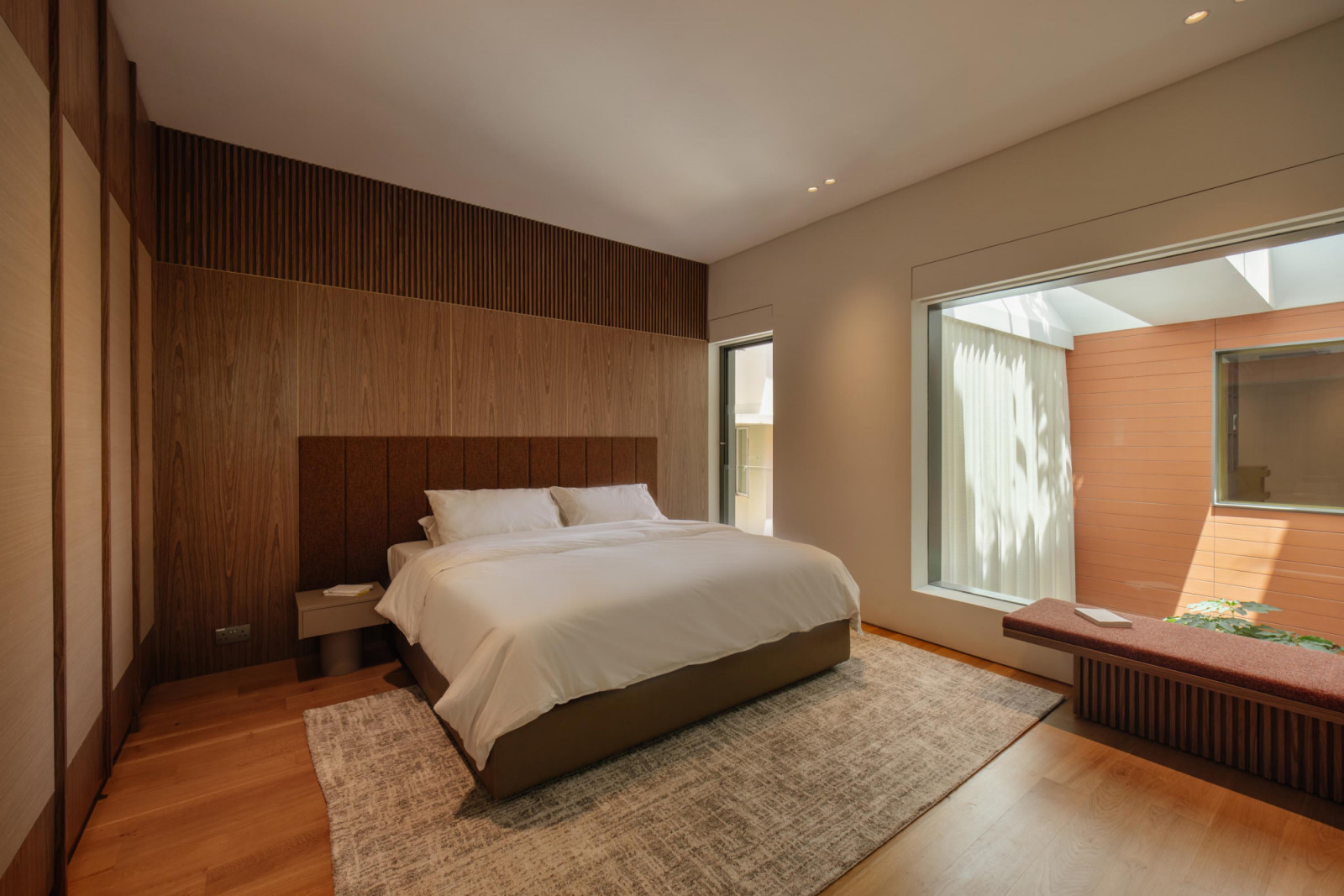 This bedroom features a large picture window that overlooks the double-volume living area