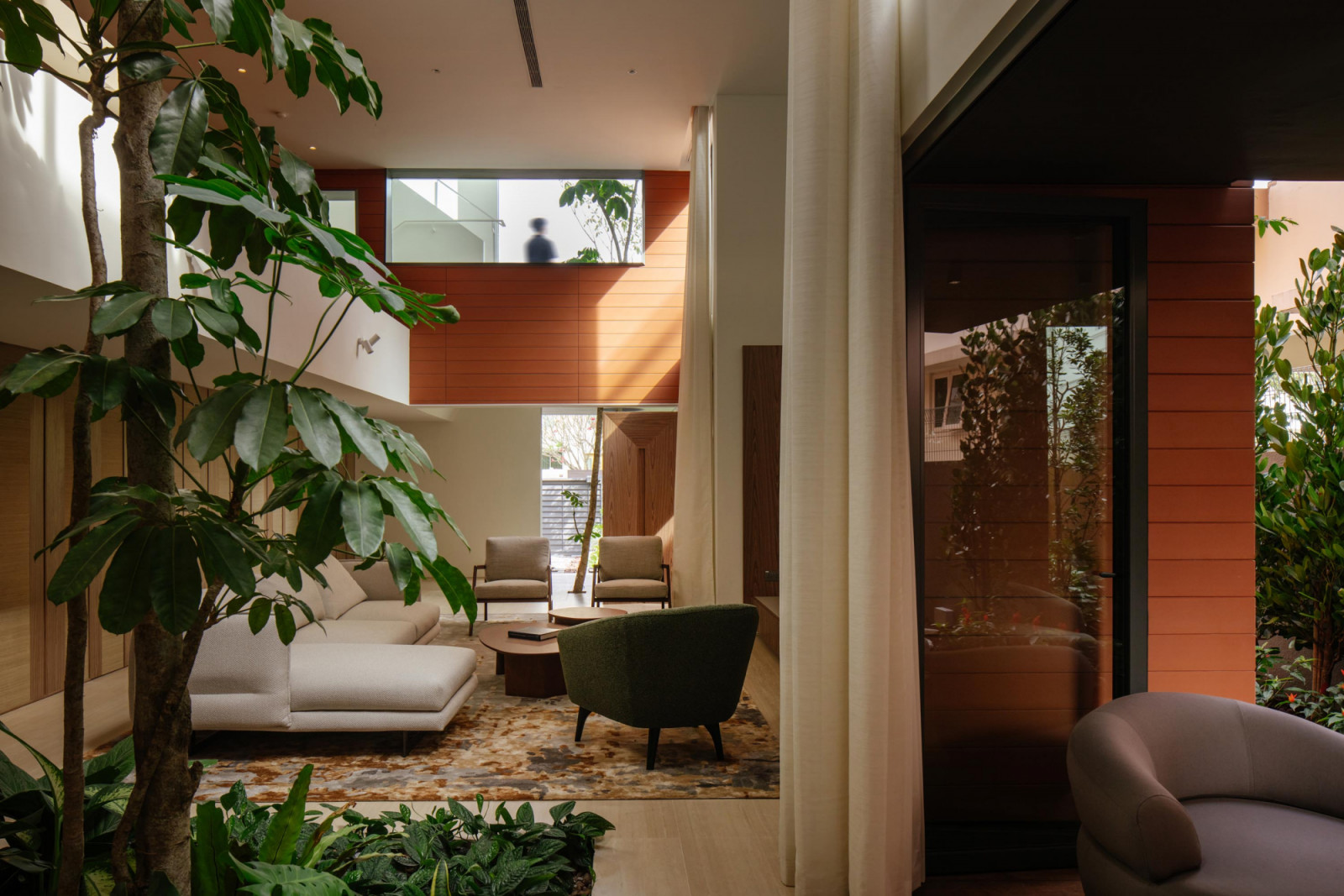 The living area features pockets of greenery and light that create a feel of being in the garden