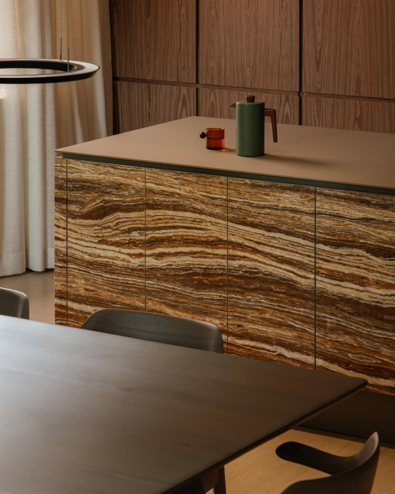 The kitchen island’s finishes lends a graphic yet still natural pattern to the material palette