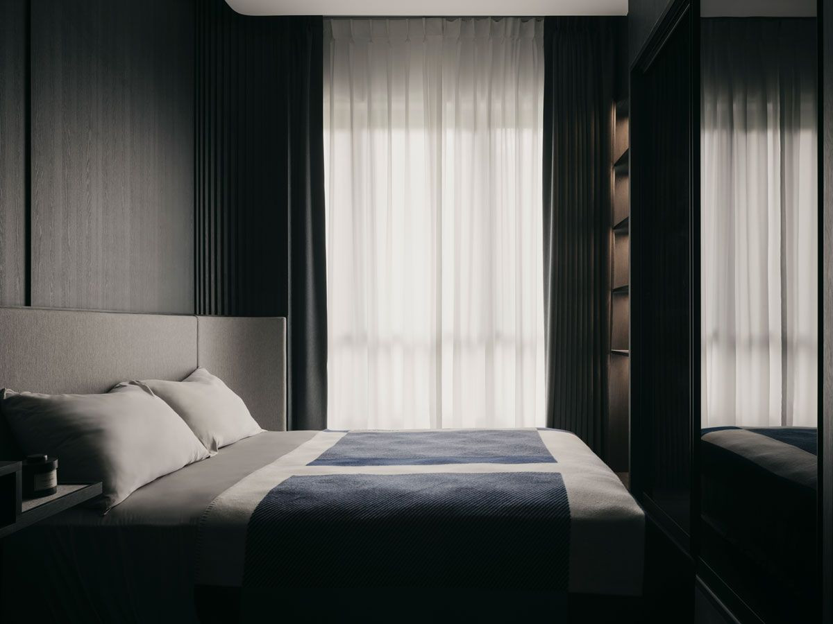 The bedroom includes a closet with mirror doors placed in front of the bed to further extend the space