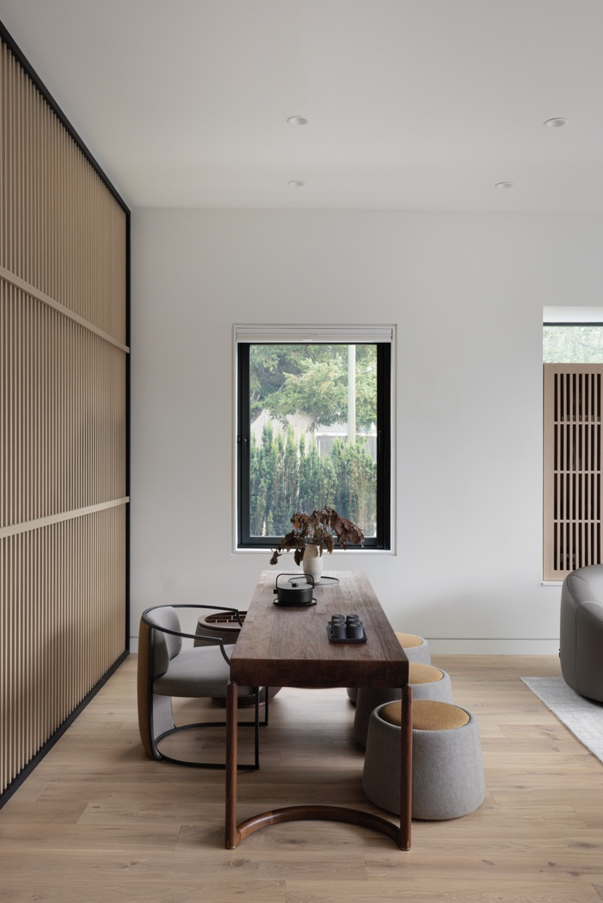 The tea table area shows how the wood slatted walls facilitate natural light flow while creating separation between spaces, embodying the traditional Chinese “ping feng” concept in a contemporary interpretation