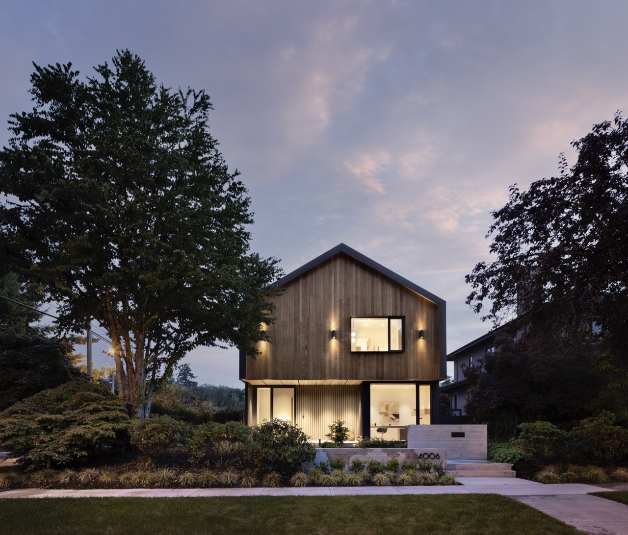 The street view shows the Vancouver house integration into the established Dunbar neighbourhood, with mature trees providing natural context for the cedar and metal exterior materials