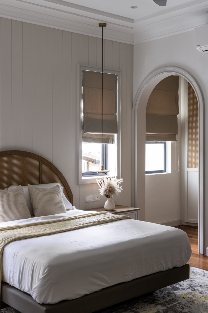 Bedrooms feature decorative grid ceilings and cane headboards with neutral linens and warm wood flooring