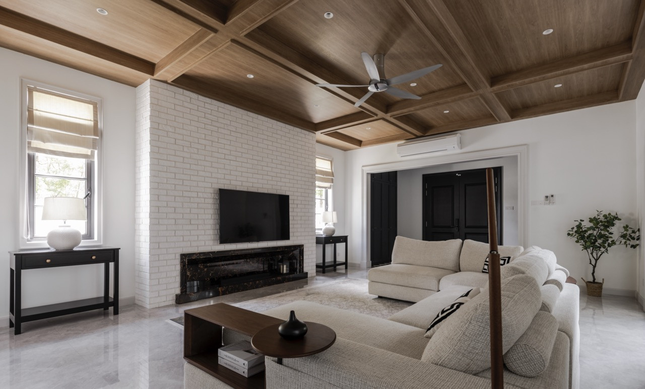 The living space features coffered wood ceilings and a white brick fireplace wall, with neutral furnishings introducing comfort beneath the cathedral-like proportions