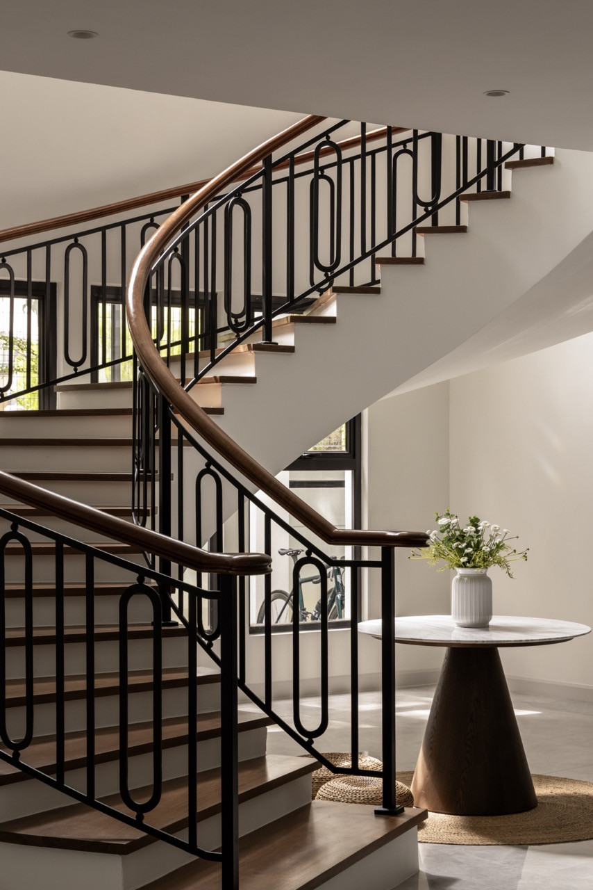 The sculptural spiral staircase introduces movement and drama to the home’s core