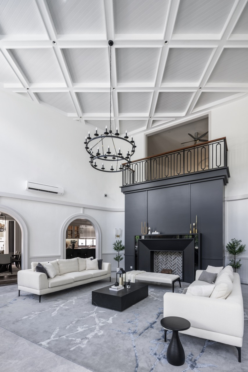 The dramatic double-height living space exemplifies the transitional design approach, seamlessly merging classical country house charm with a clean, modern sensibility