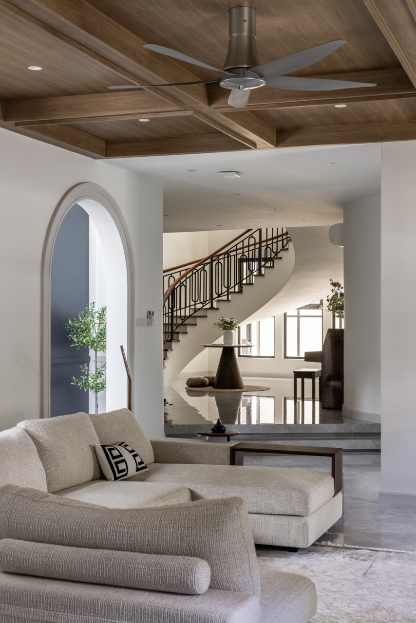 The double-height living space features coffered wood ceilings and a white brick fireplace wall