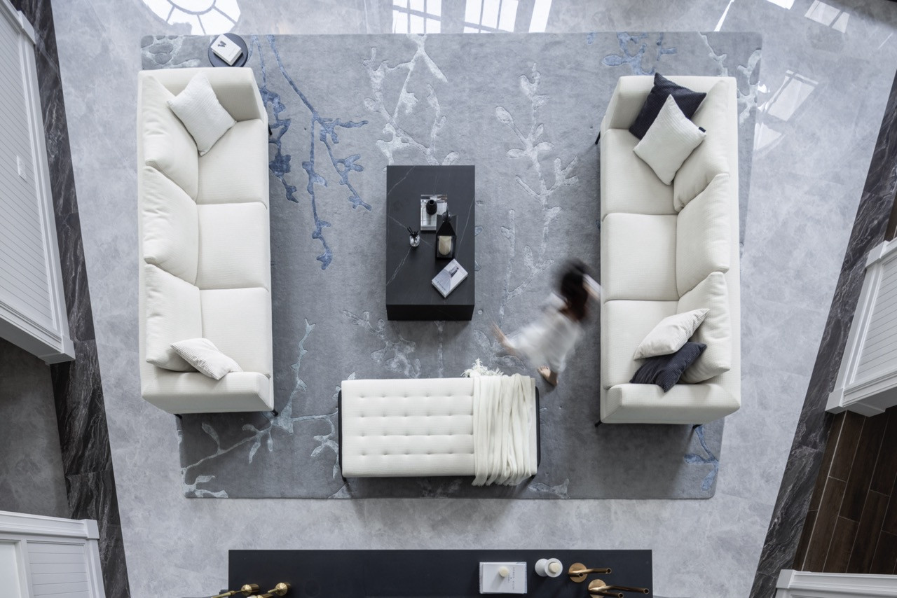 Viewed from above, the double-height living space reveals its dramatic proportions and natural light flooding through arched windows and black-framed French doors
