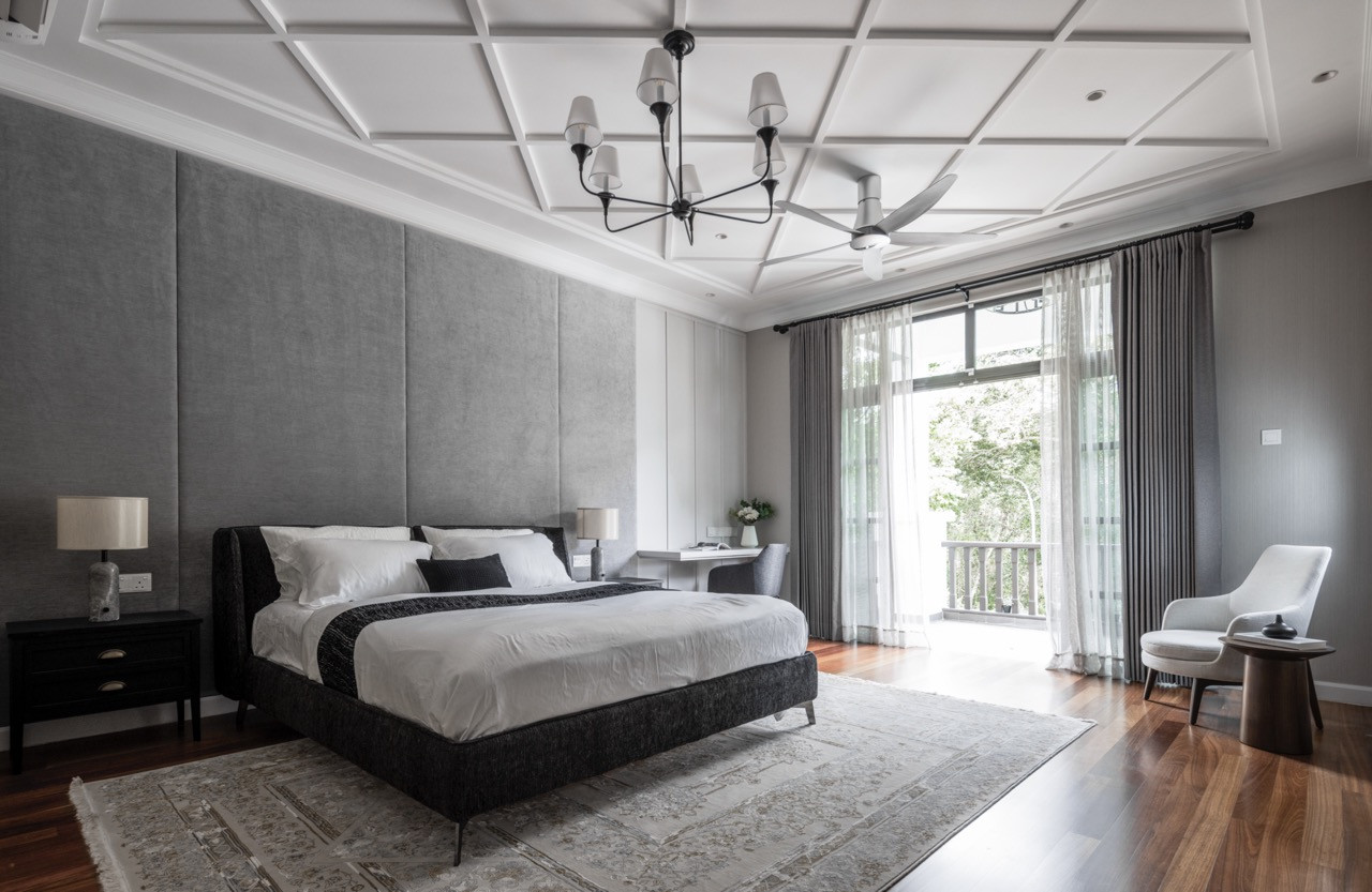 A guest bedroom showcases the home’s consistent approach to ceiling treatments with coffered details
