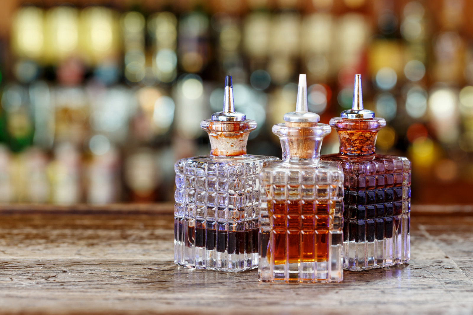 Inventory of the bartender at the bar counter - droppers for bitters and syrups stand in a row on a blurred background of the bar