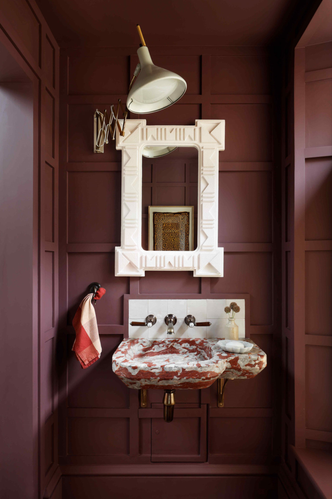 The powder room in deep burgundy with bespoke marble basin